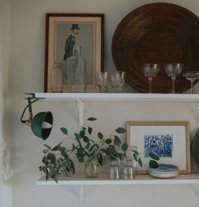 Bild av stilfull hylla med grön lampa och glasdetaljer