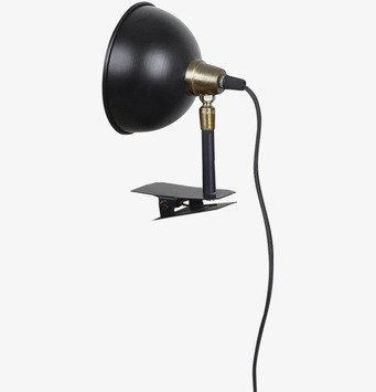 Foto av svart lampa med klämfäste och mässingsdetaljer