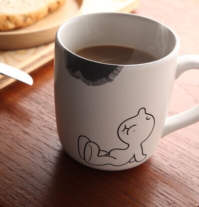 Bild av stilfull mugg med ånga och bröd i bakgrunden