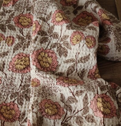 Bild av dekorativ löpare med blommotiv och jordnära toner