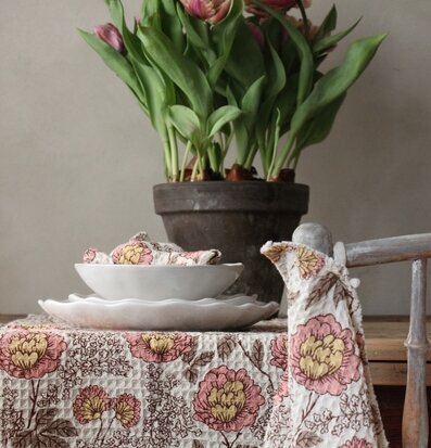 Bild av hemtrevlig dukning med blommönstrade textilier