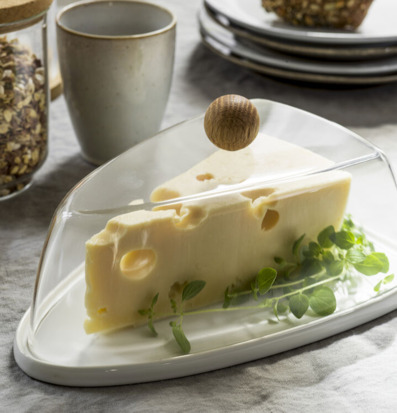 Bild av ostkupa med trähandtag och hemtrevlig dukning