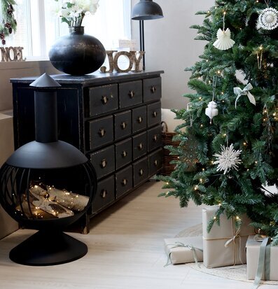 Bild av julgran och eldstad i mysig interiörmiljö