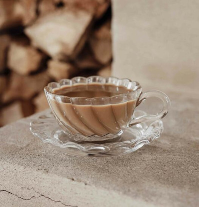 Bild av elegant kopp i klart glas med vågig struktur