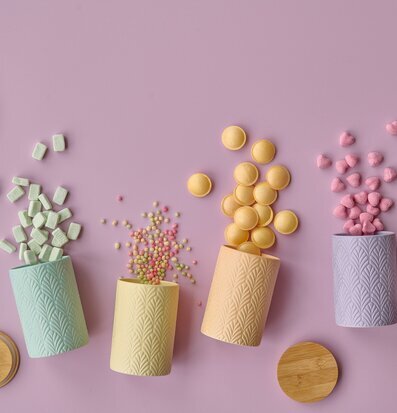 Bild av fyra keramiska förvaringsburkar på lila bakgrund
