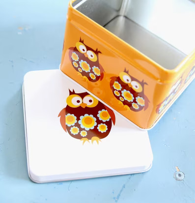 Bild av färgglad och praktisk plåtbox med ugglemotiv