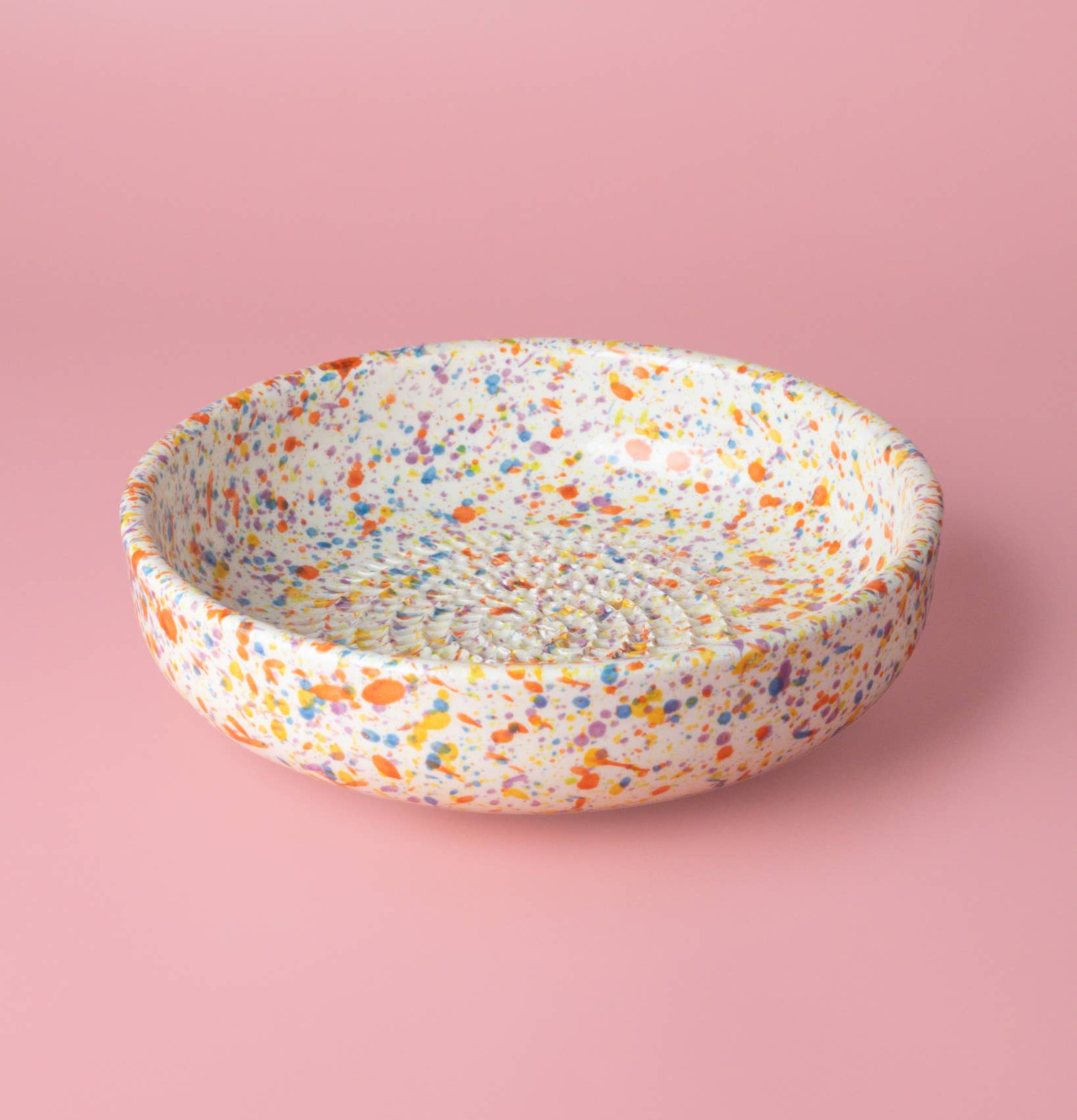 Bild av färgglad keramisk rivplatta med träsked