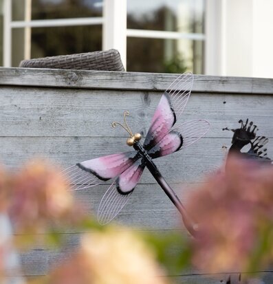 Bild av dekorativ trollslända i rosa och svart plåt