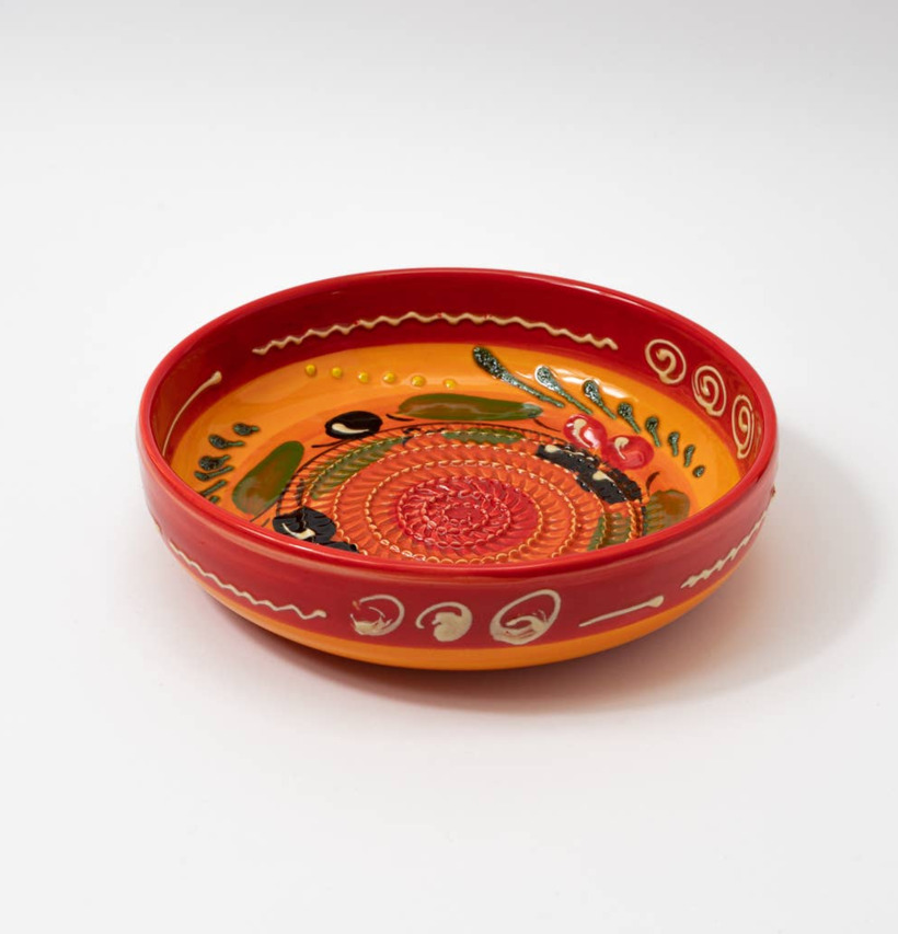 Bild av färgglad keramisk rivplatta med handmålat motiv