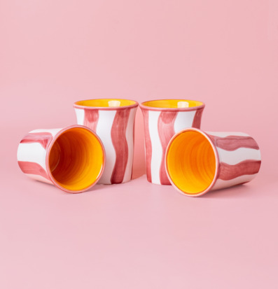 Bild av fyra unika keramiska koppar på rosa bakgrund