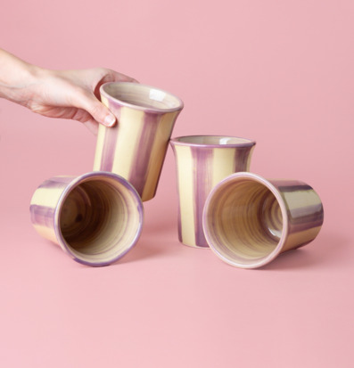 Bild av eleganta keramiska koppar i crème och lila toner