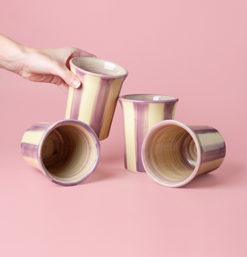 Bild av eleganta keramiska koppar i crème och lila toner