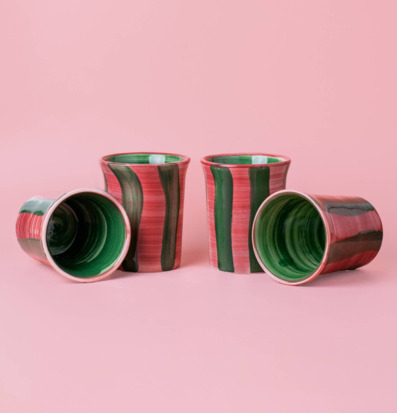Bild av fyra keramiska koppar med rosa och gröna toner