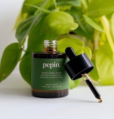 Bild av stilren flaska med växtserum och grön bakgrund