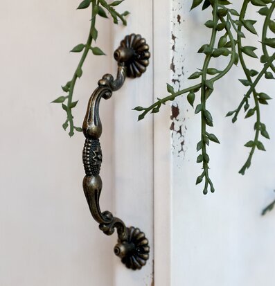 Bild av antikt väggskåp med detaljerat metallhandtag