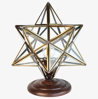 Foto av en stjärnformad bordslampa med glas och metall
