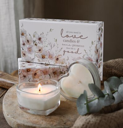 Bild av doftljus i hjärtformad glasbehållare och träbricka