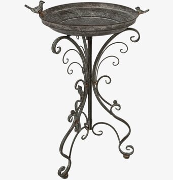 Foto av elegant fågelbad på rustik piedestal i trädgård