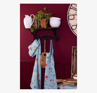 Bild av rustik vägghylla med krokar mot vinröd vägg