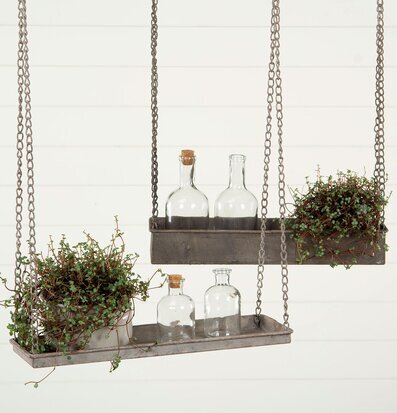 Bild av hängande metallhylla med växter och glasflaskor