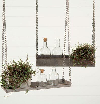 Bild av stilren hängande hylla med glasflaskor och växter