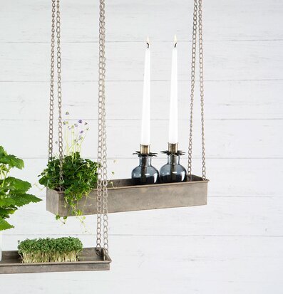 Foto av stilren hängande hylla med växter och ljusstakar