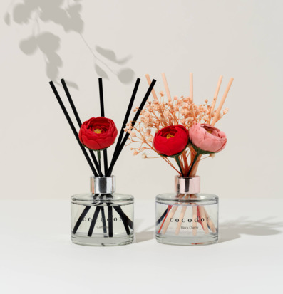 Bild av eleganta flakonger med doftpinnar och blommor