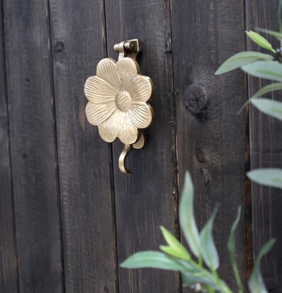 Bild av antik dörrklapp i mässing på rustik träport