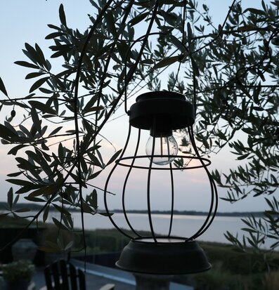 Bild av solcellslanterna i kvällsro vid vattendrag