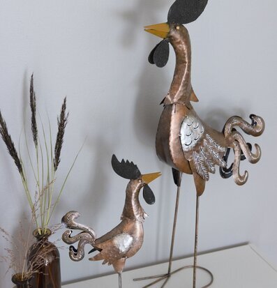 Bild av två dekorativa tuppskulpturer i metall