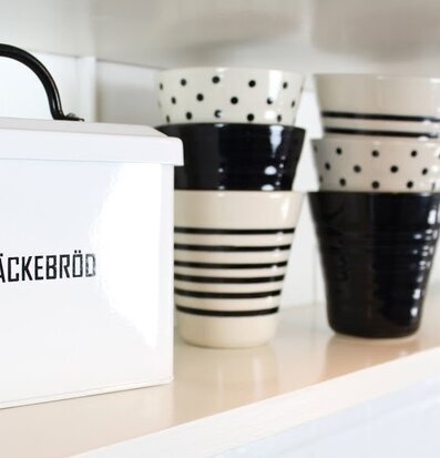 Bild av stilfullt köksarrangemang med brödburk och muggar