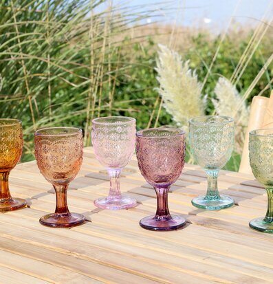 Foto av färgglada aperitifglas på träbord utomhus