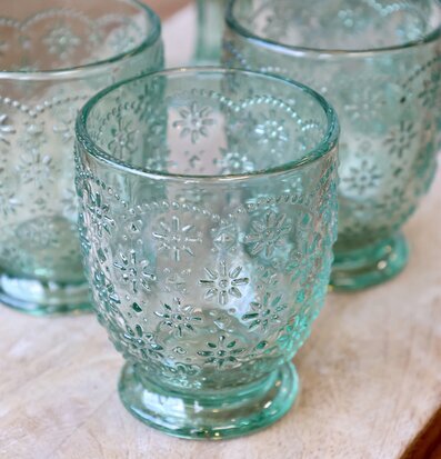 Foto av eleganta reliefglas med blommönster och grönton