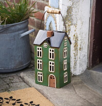 Bild av stiliserad grön ljuslykta i rustik utomhusmiljö