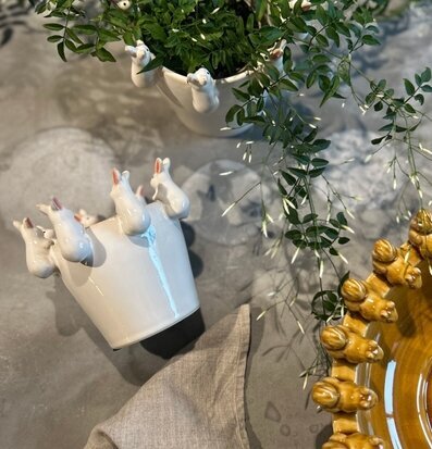 Foto av charmig vit keramik med kaninmotiv och växt