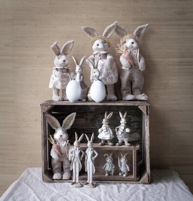 Bild av charmiga påskharar på rustik trähylla