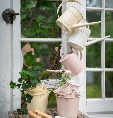 Foto av charmiga vattenkannor i lantlig trädgårdsmiljö