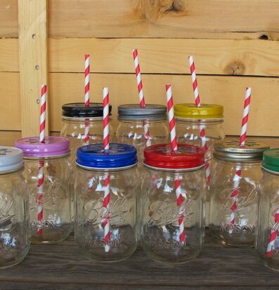 Bild av åtta glasburkar med färgglada lock och sugrör