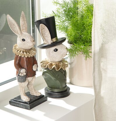 Foto av kaninskulpturer och växt på fönsterbräda