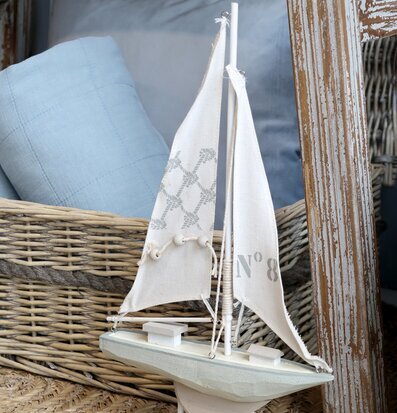 Bild av maritim inredning med segelbåt och rottingkorg