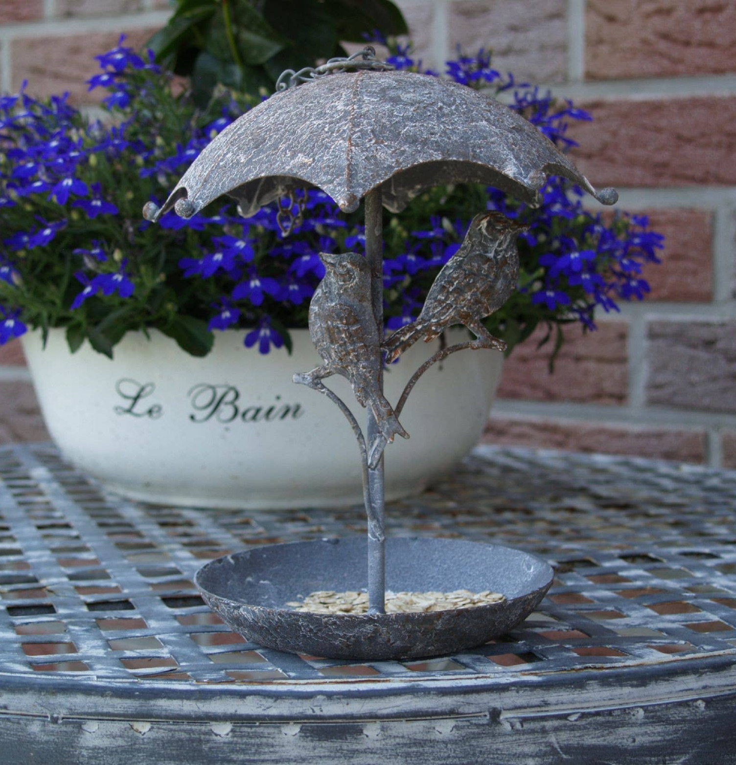 Bild av dekorativt fågelbad i lantlig trädgårdsmiljö