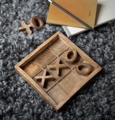 Bild av gemütlig scen med träbrädspel och anteckningsbok