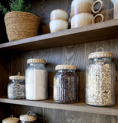 Bild av rustik hylla med glasburkar och dekorativa detaljer