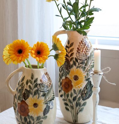 Bild av harmonisk scen med kannor och blomstermotiv