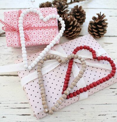 Bild av julig scen med pärlor, presenter och kottar