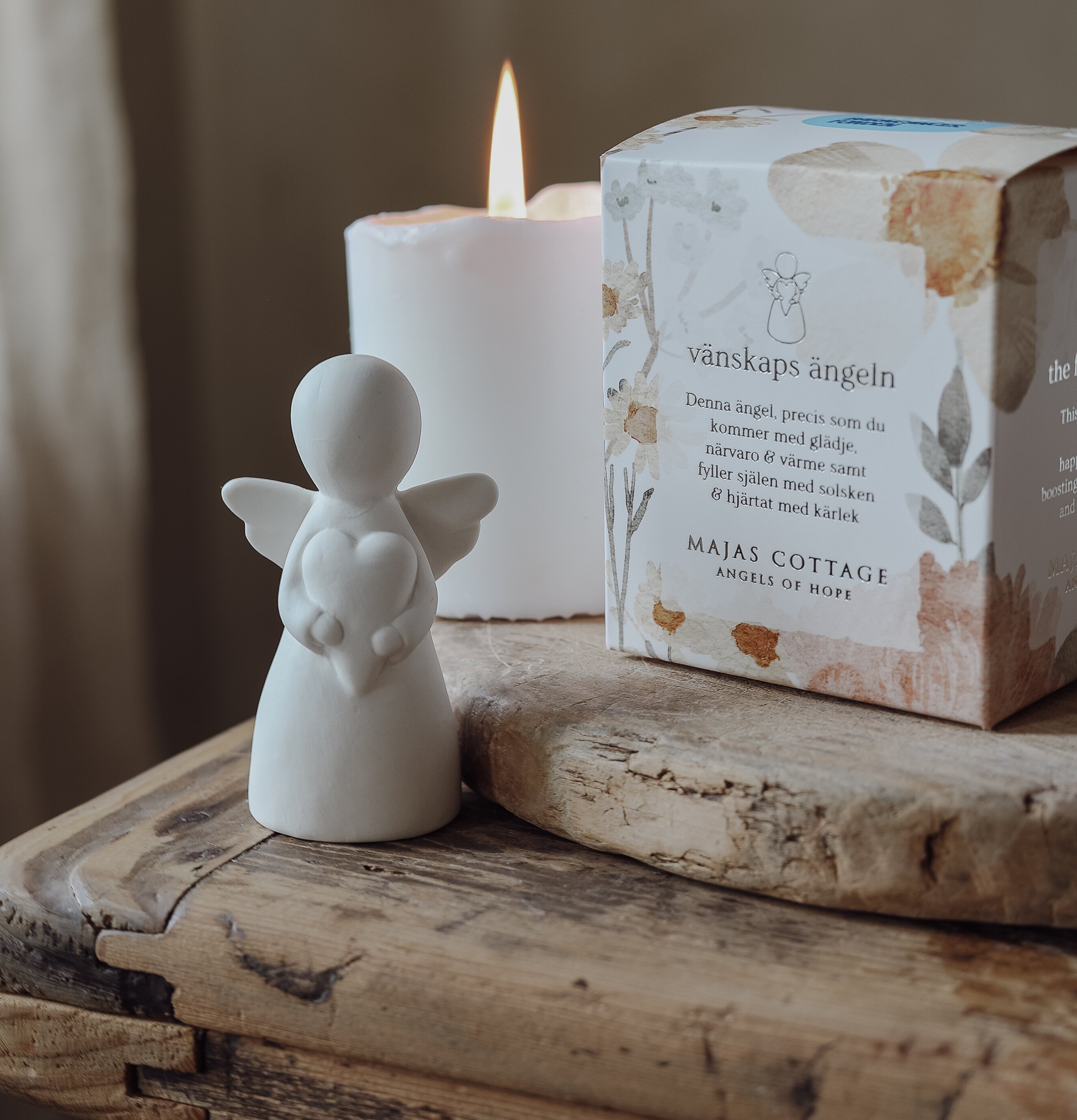Bild av keramikängel med hjärta och ljus i hemtrevlig scen