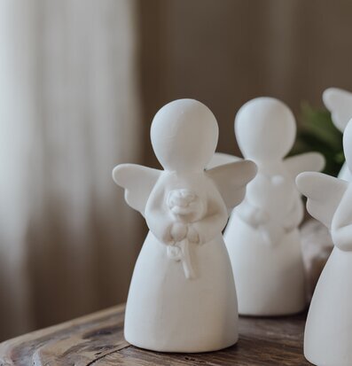 Bild av en stiliserad ängel med blomma och gåvobox