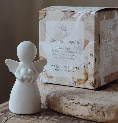 Bild av stilren ängelstatyett på rustikt träbord