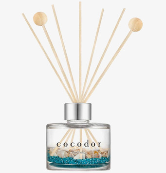 Bild av doftpinnar i elegant glasbehållare med pärlor