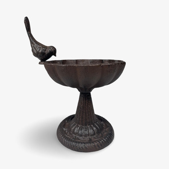 Foto av rustikt fågelbad med dekorativ fågel på kanten